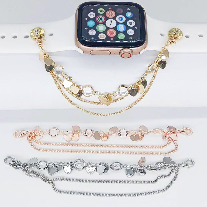 Smartwatch with multiple gold, rose gold, and silver bracelets on a white surface