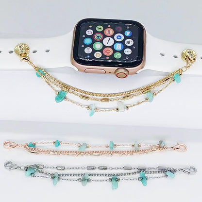 Smartwatch with a gold bracelet featuring turquoise stones on a white surface