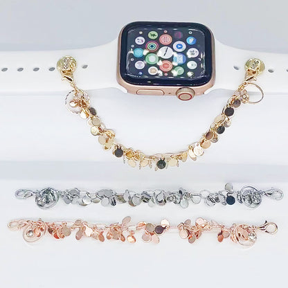 Smartwatch with a decorative charm bracelet on a white surface