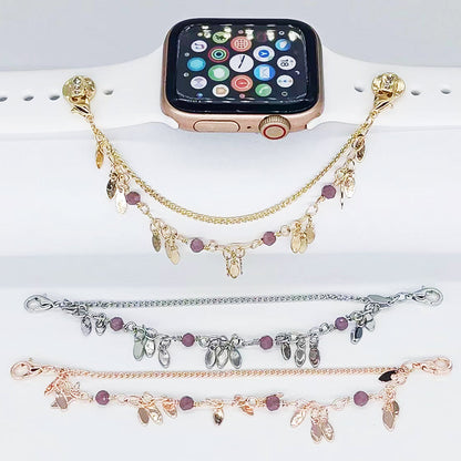 Smartwatch with gold, silver, and rose gold charm bracelets on a white surface