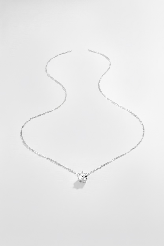 A delicate silver chain necklace with a small clear gemstone