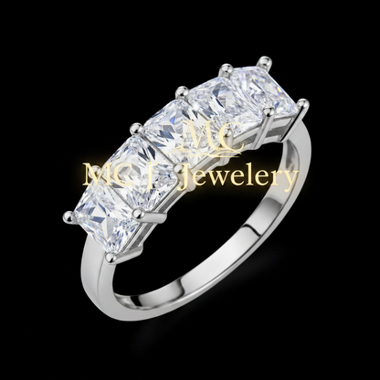 A five-stone ring featuring rectangular princess-cut clear gemstones in a silver-colored metal setting, shown on a solid black background.