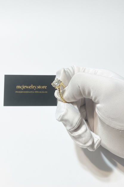 A jeweler holding a jewel ring is 3ct Moissanite with business card in shop