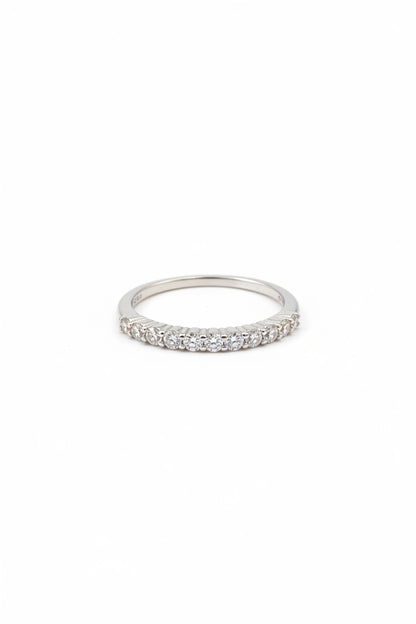 A silver-tone eternity band ring set with small round-cut clear gemstones, shown against a plain white background.