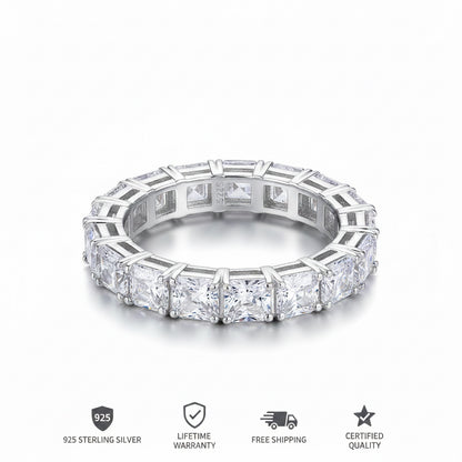 A silver-toned eternity ring featuring a continuous row of princess-cut and round diamonds in a beveled setting, shown on a clean white background.