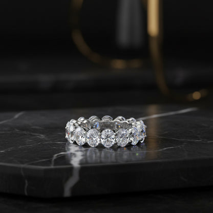 A silver-toned eternity ring featuring a row of round brilliant-cut clear stones, with an inner band stamped 'S925'.