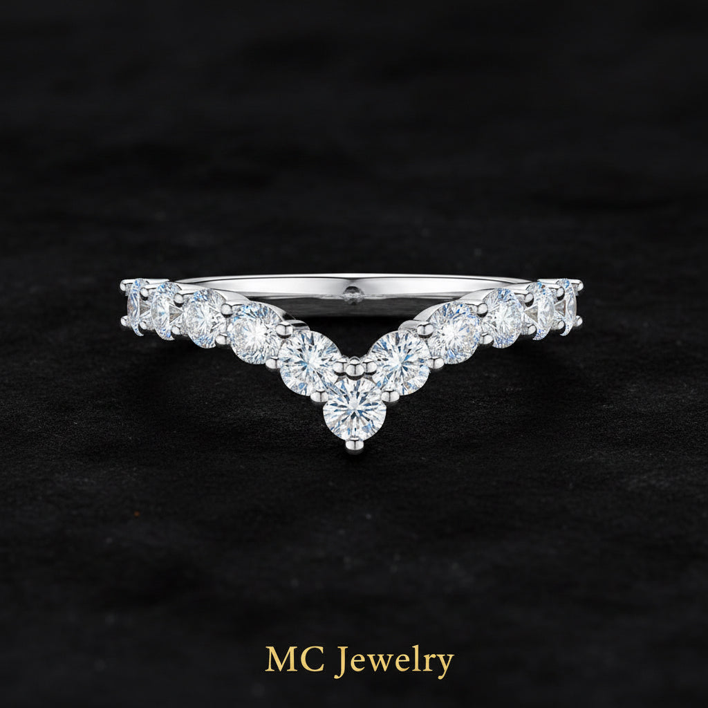 A silver V-shaped diamond ring with a pavé band and a central round diamond, shown on a clean white background.
