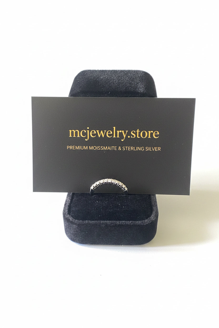 A silver ring displayed on a black velvet jewelry stand with a branded black card reading 'mcjewelry.store' in gold text, photographed against a white background.