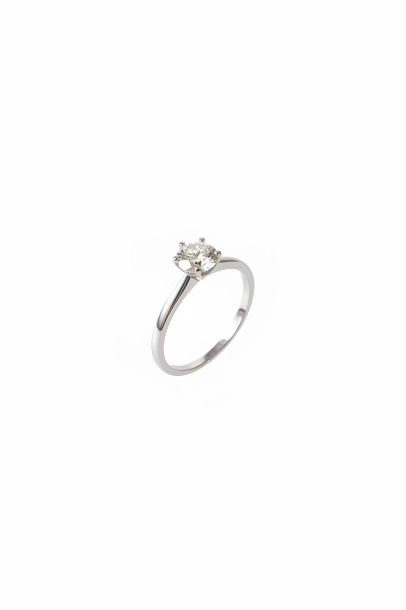 A silver solitaire engagement ring with a round clear gemstone resting 