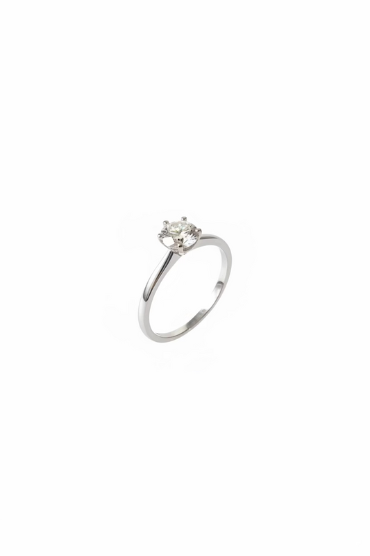 A silver solitaire engagement ring with a round clear gemstone resting 