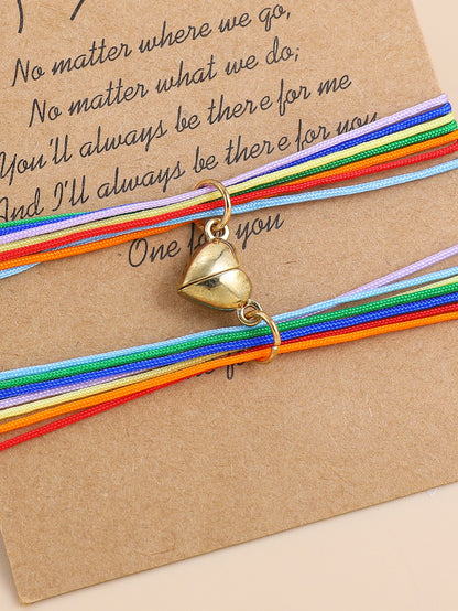 Colorful bracelet with a gold charm on a brown card with text