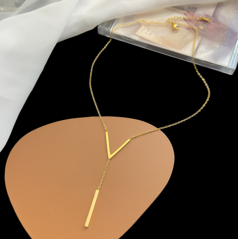 Gold necklace on a black and brown abstract background