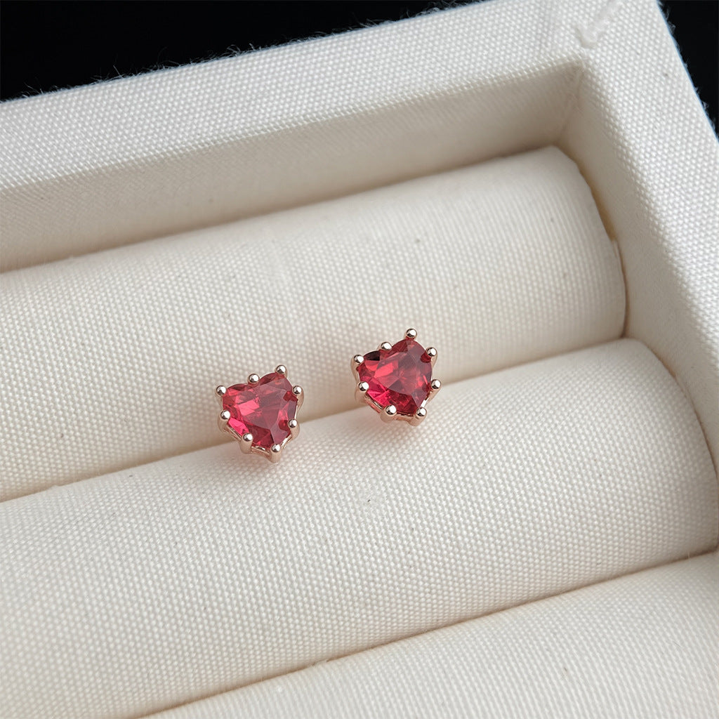Heart-shaped red gemstone earrings in a jewelry box