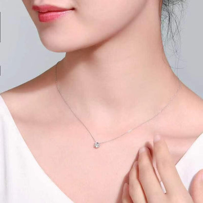 Necklace with a small pendant worn by a person on a plain background