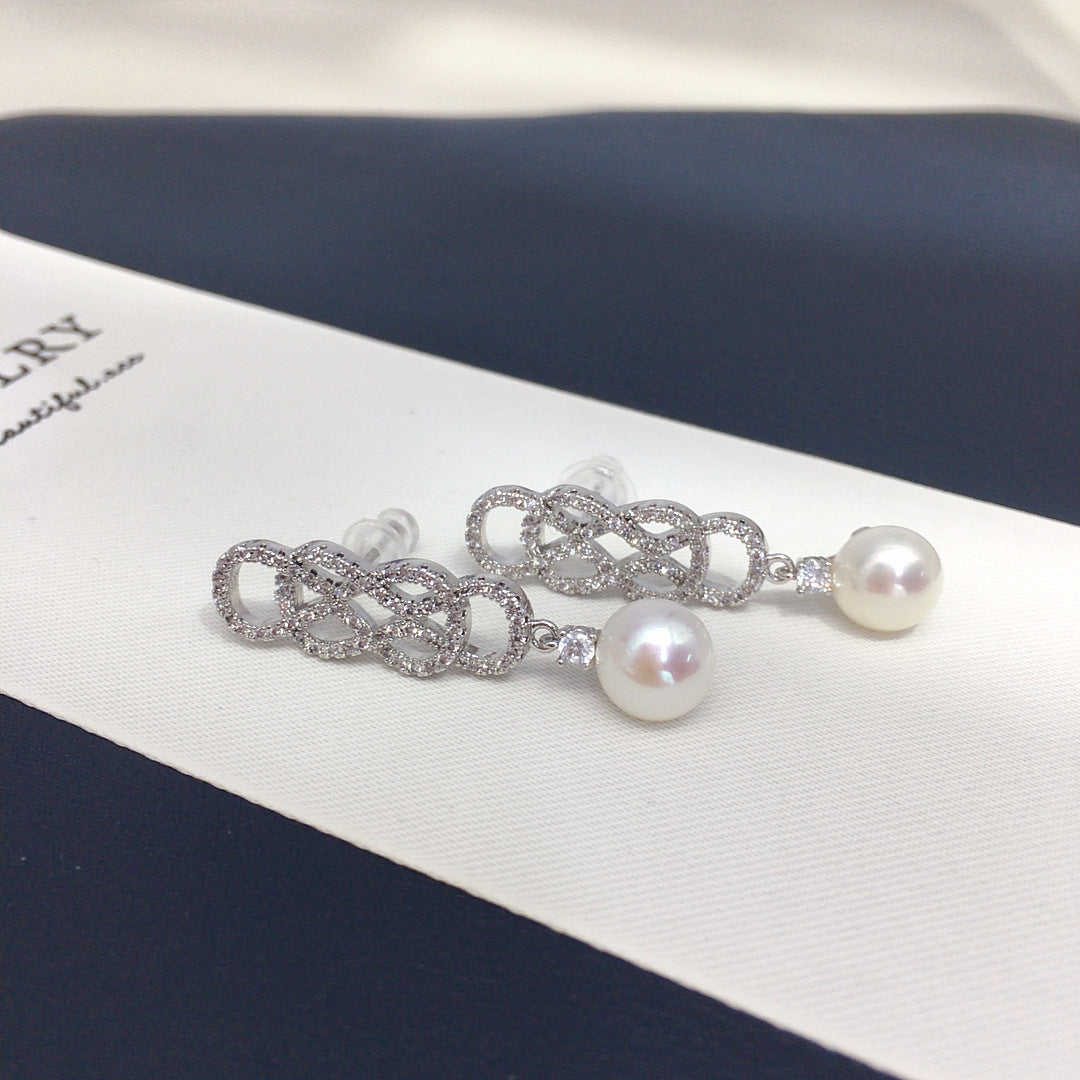 Pearl and silver chain earring on a jewelry box