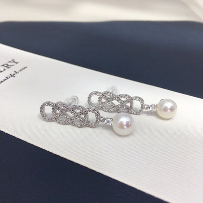 Pearl and silver chain earring on a jewelry box