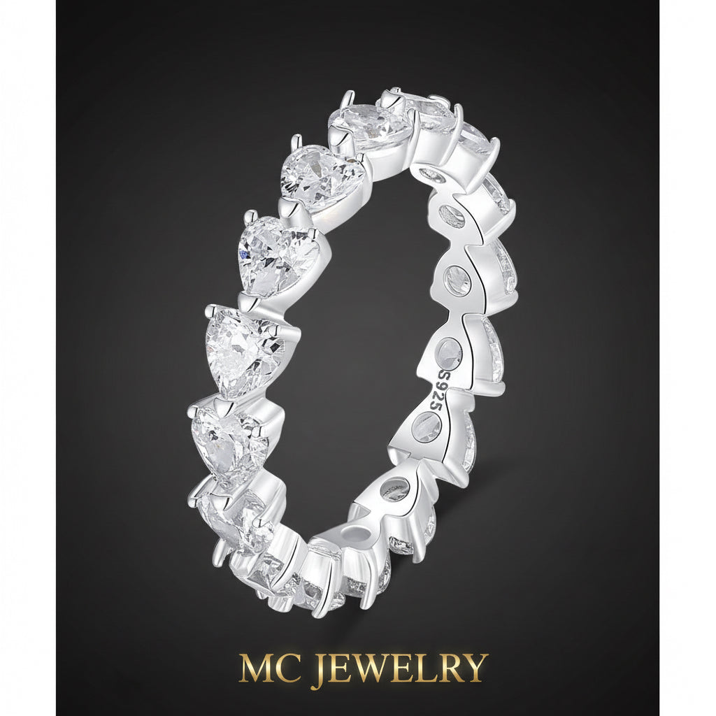 Silver ring with heart-shaped gemstones on a white background