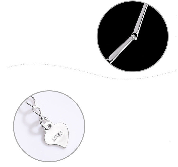 Silver necklace with a heart-shaped pendant on a white background