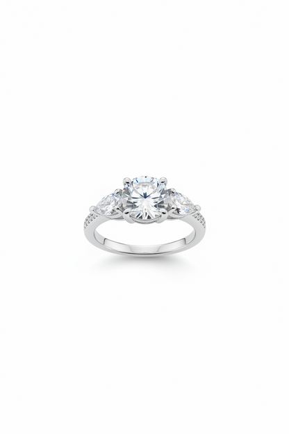 A silver-toned diamond ring with a large round center stone and smaller side stones, shown on a plain white background.