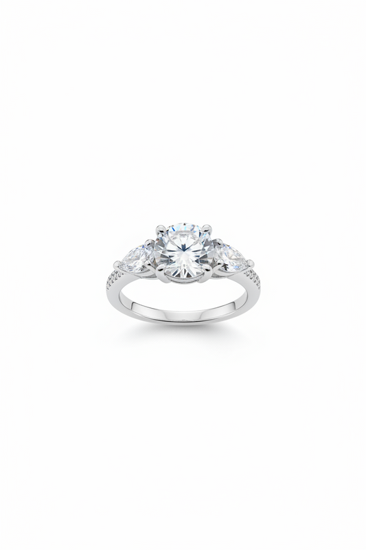 A silver-toned diamond ring with a large round center stone and smaller side stones, shown on a plain white background.