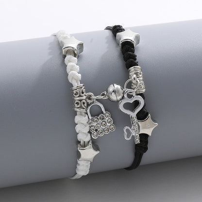 Two bracelets with star and lock charms on a gray surface