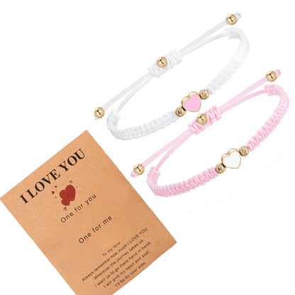 Two bracelets, one white and one pink, with heart-shaped beads on a 'I LOVE YOU' card.