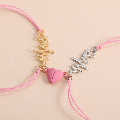 Two pink bracelets with gold and silver charms on a beige background